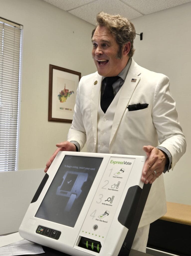 Lee Dean demonstrating how to use a voting machine.